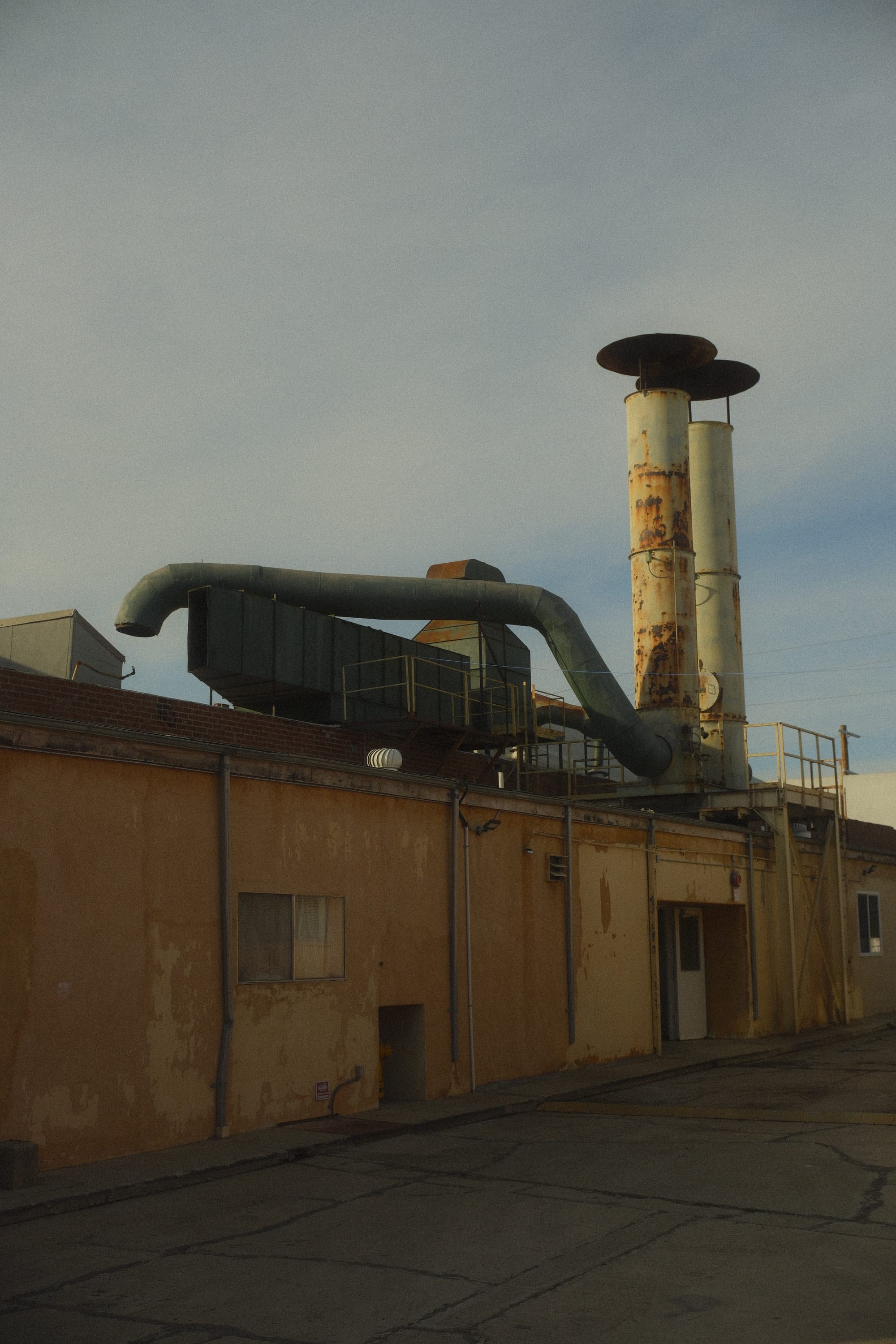 some industrial pipes with rust on them. the skies are blue. 