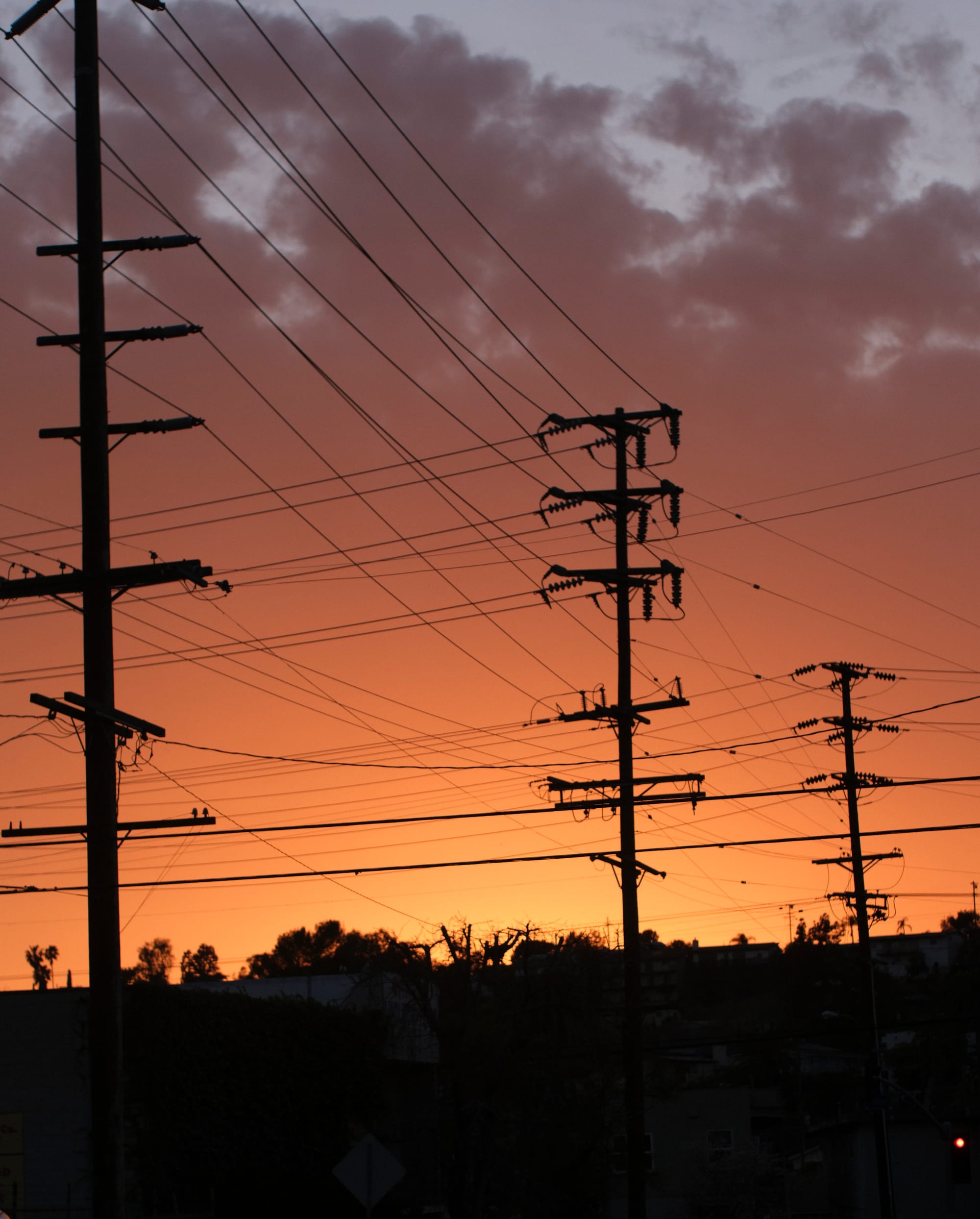 a photo of some power lines against an orange sunset